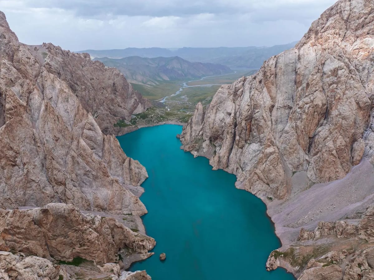 Kel-Suu Lake surrounded by dramatic mountain cliffs