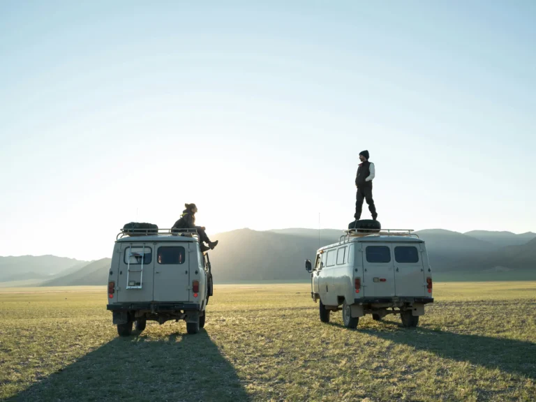 Travelers enjoying sunset on a Bukhanka off-road vehicle